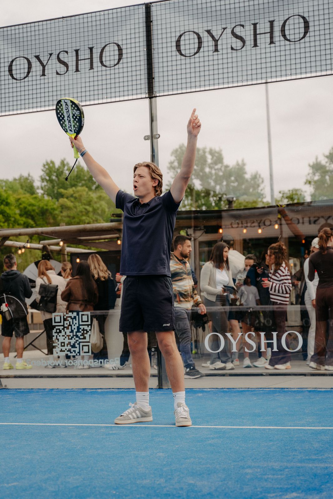 Player with arms raised under the OYSHO court sign in Amsterdam